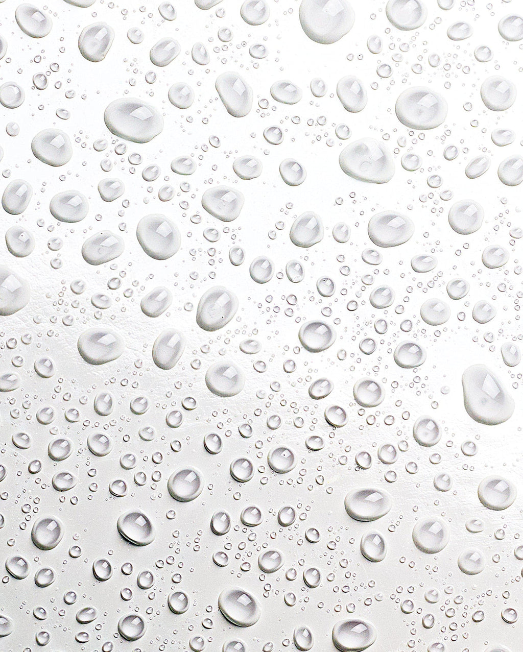 Bambu Earth Helichrysum Hydration Facial Mist - Clear water droplets of varying sizes scattered across a glossy white